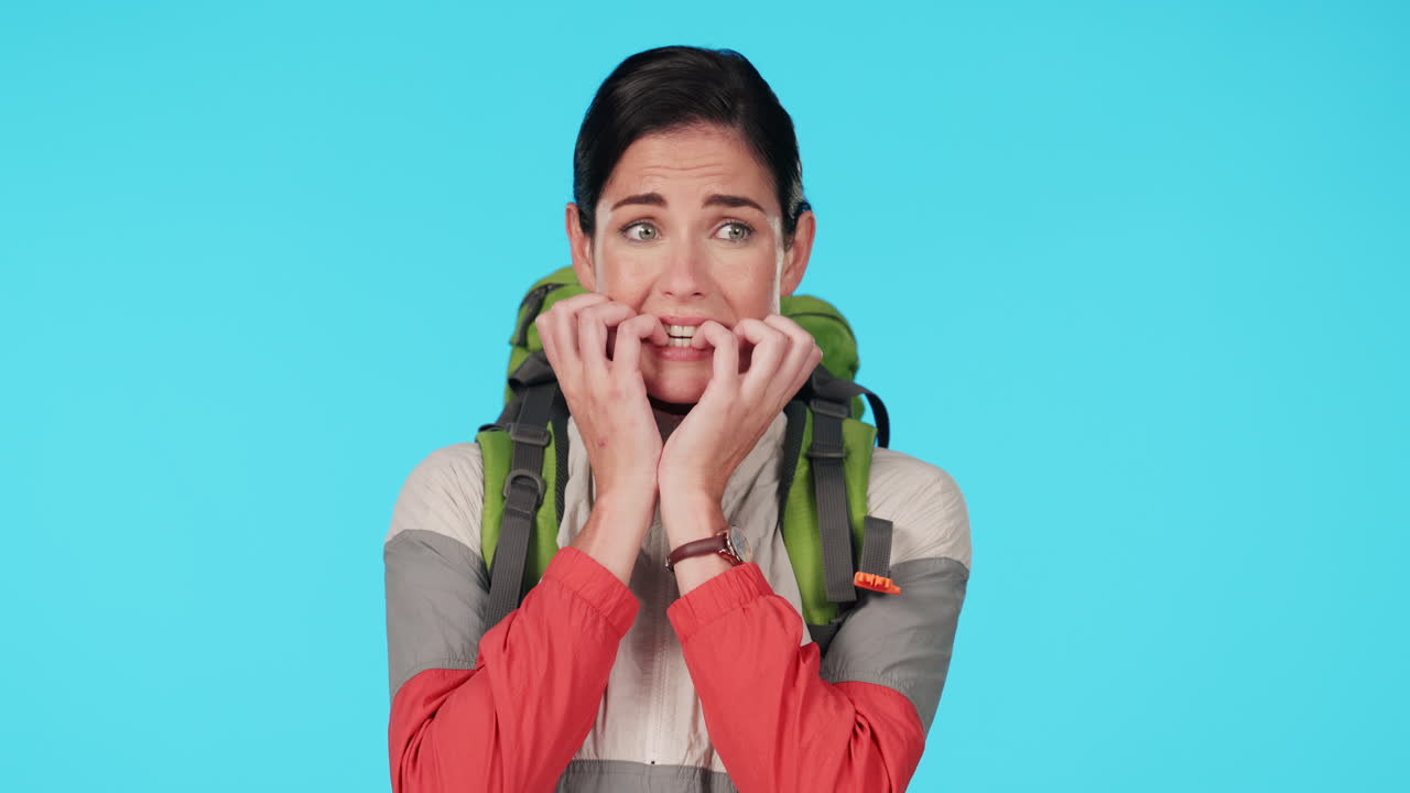 Hiking, nervous and scared woman in studio biting