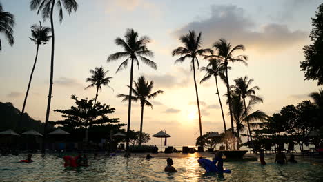 Zeitraffer---Swimmingpool-Und-Silhouette-Palme-Mit-Sonnenuntergang