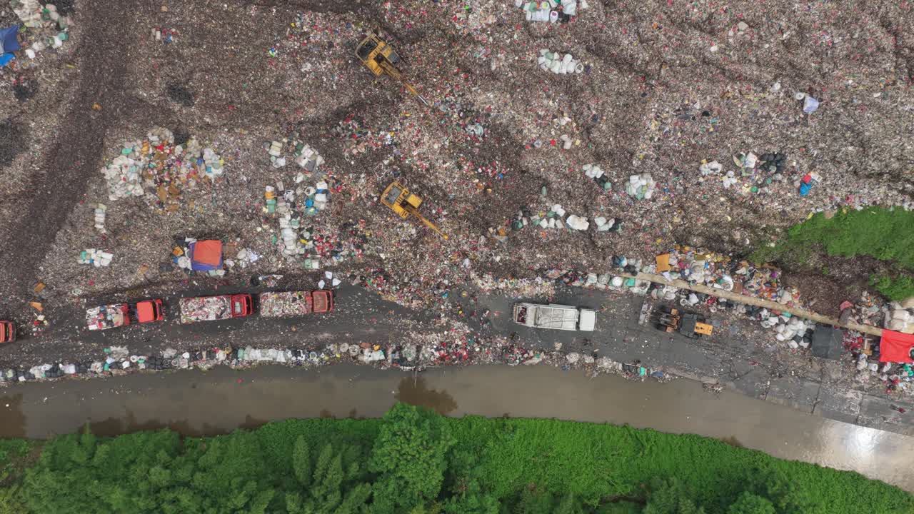 Aerial view of garbage trucks unloading at bantar gebang landfill in jakarta