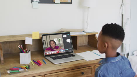 escolar que usa una computadora portátil para la lección en línea en casa, con su colega y el chat web en la pantalla
