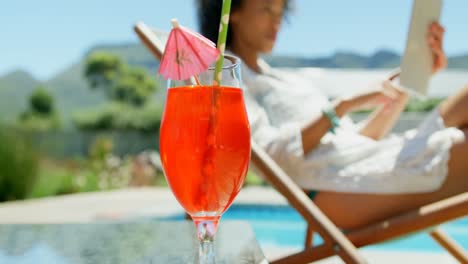 close-up of cocktail drink on a table near swimming pool 4k