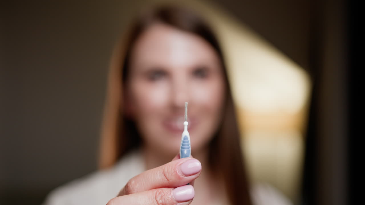mujer con un cepillo interdental