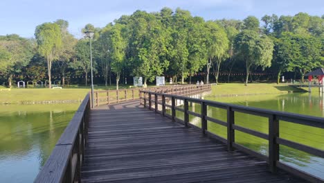 a wooden bridge gracefully spans a tranquil lake, designed exclusively for pedestrian use. this scenic walkway offers serene views of the surrounding waters.