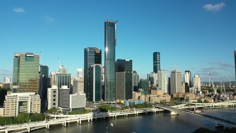 toma aérea de drones del paisaje urbano de brisbane desde el extremo oeste, mientras la cámara vuela con gracia hacia atrás, revelando un gran edificio de apartamentos en el corazón del extremo oeste