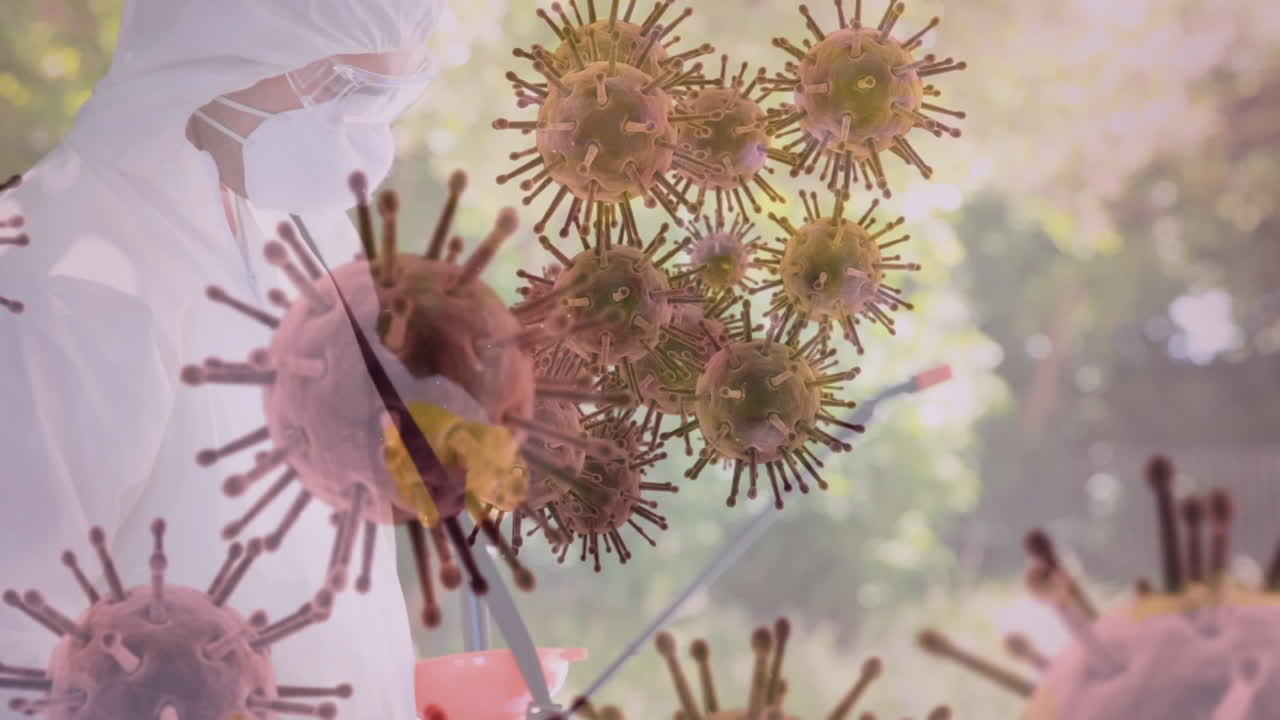 Animation of covid 19 cells over healthcare worker in ppe suit disinfecting with spray