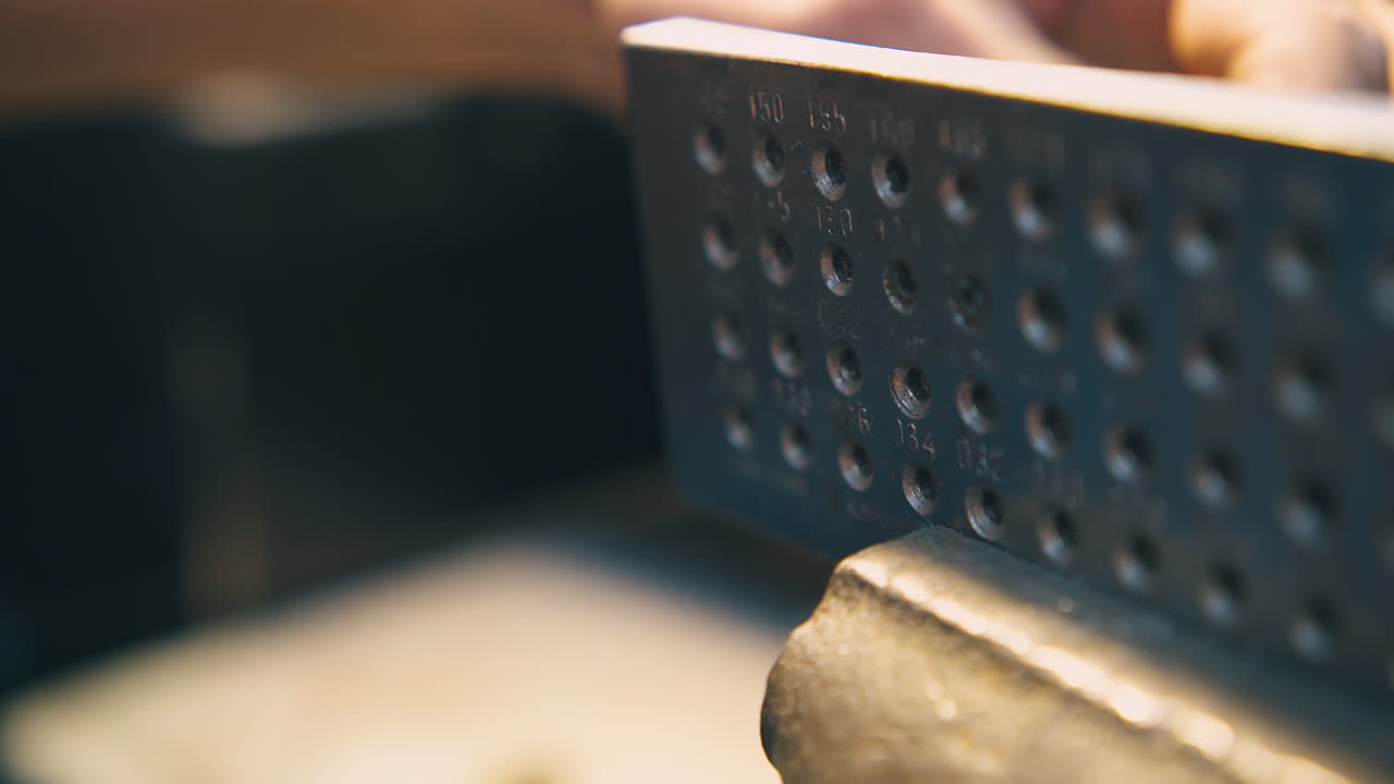 금공 이 보석 에 있는 구 ⁇  을 통해 와이어를 끌고 가고 있다