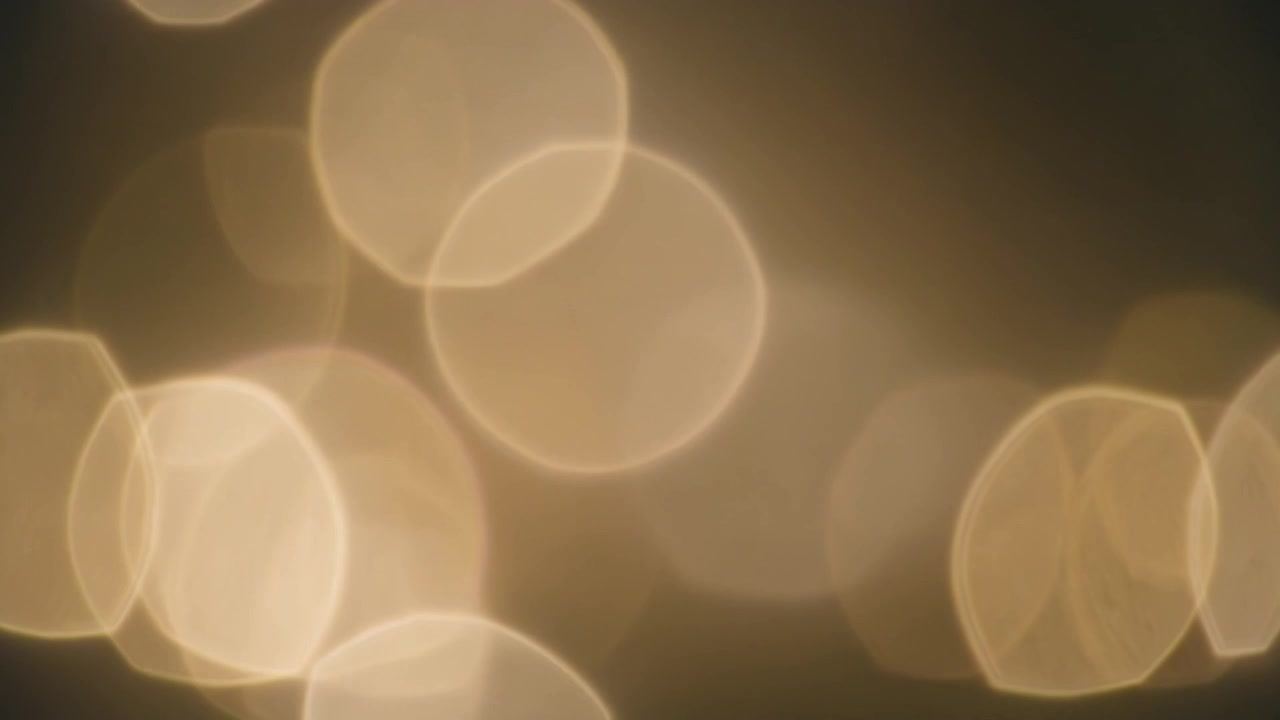 Abstract Golden Bokeh Light Particles Floating on Dark Background