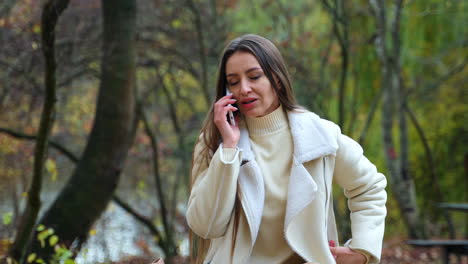 woman talking on phone in autumn park