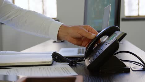 executive putting down phone receiver at desk in office 4k