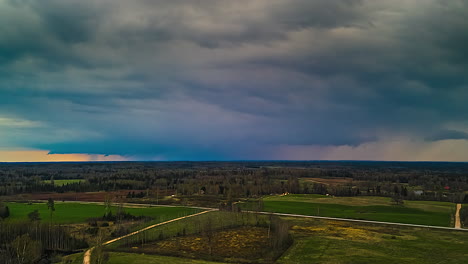 rainstorm over rural farms and forests in the european countryside - aerial hyperlapse