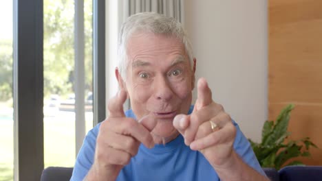 portrait of happy senior caucasian man making video call at home, unaltered, in slow motion