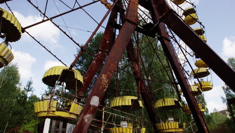 rustic ferris wheel with yellow baskets in pripyat, tilting up view