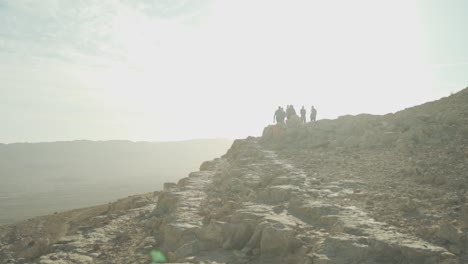 group of travellers walking on desert ridge in the sun