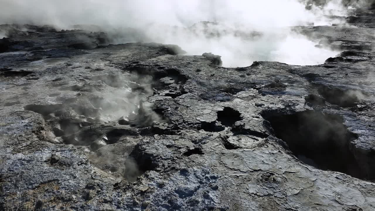 Low slow Drone flying over geothermal landscape. Trees, steam, bubbling mud and steam. Alien Landscape. Sci-fi. Global Warming