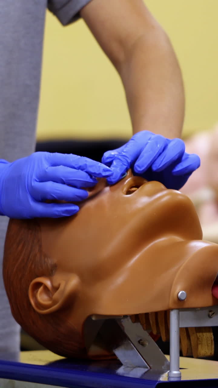 Medic conducts medical teaching. Instructor teaching practical technologies on a dummy head in medical center. Vertical video