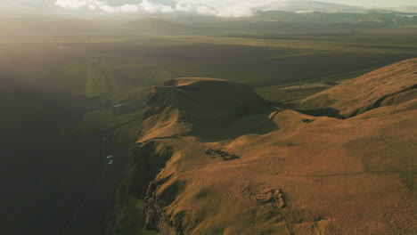 Aerial-parallax-around-towering-bluff-and-cliff-overlooking-valley-in-Iceland