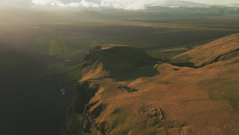 aerial parallax around towering bluff and cliff overlooking valley in iceland