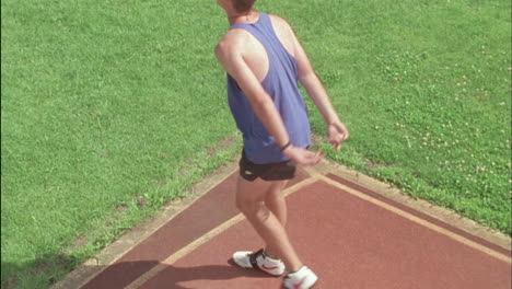 a man runs down the field to throw a javelin