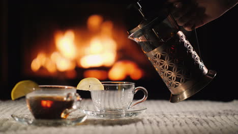 pour tea into a cup on the background of the fireplace tea in a cozy setting