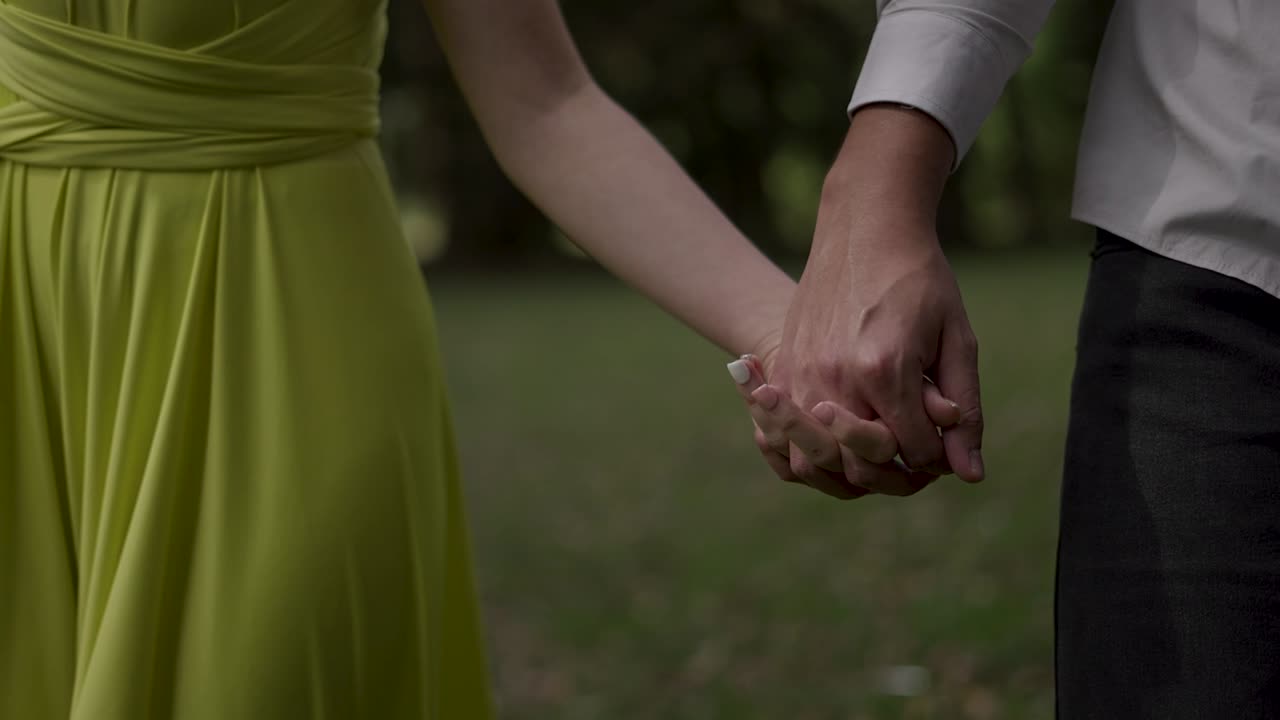 una pareja de manos en un parque.