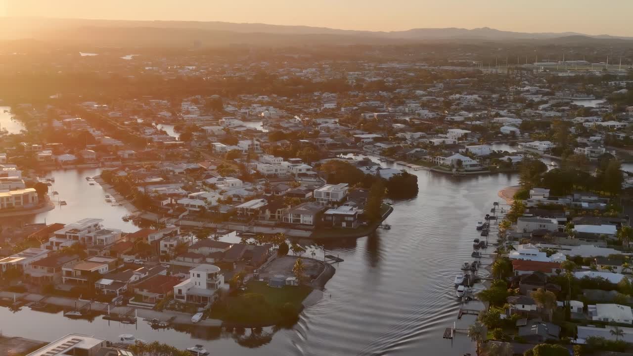 Aerial view of a tranquil residential area with a winding waterway at sunset, capturing the peaceful ambiance.