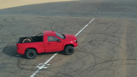 racing truck driving on tarmac road in the desert, drone orbiting