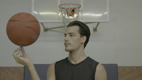 primer plano, hombre girando baloncesto en el dedo en el lado izquierdo, espacio de copia