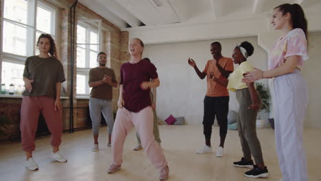 woman dancing for group of multiethnic students