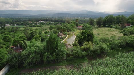 drone aéreo tiro ancho de árboles y hermoso paisaje con cuerpo de agua en primer plano nubes y niebla en el fondo