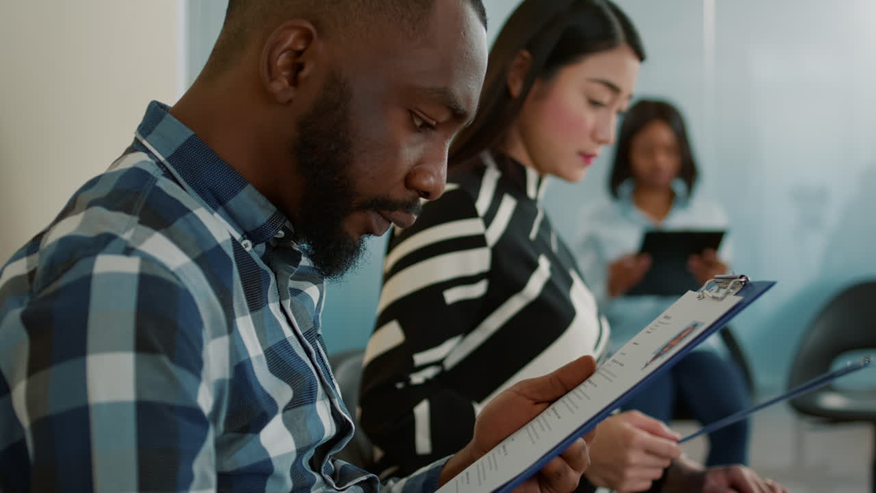 African american candidate looking at curriculum vitae in hand