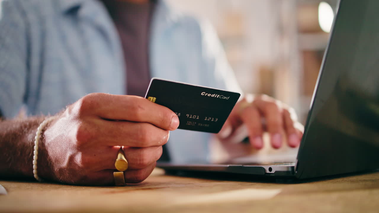 Person's Hands Using Credit Card for Online Shopping on Laptop