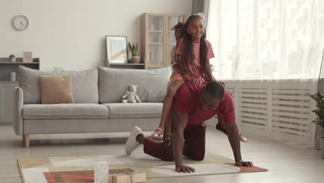 man riding little daughters on back