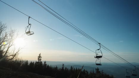sunset with chairlifts on ski mountain during spring summer with mountain skyline 4k 30p