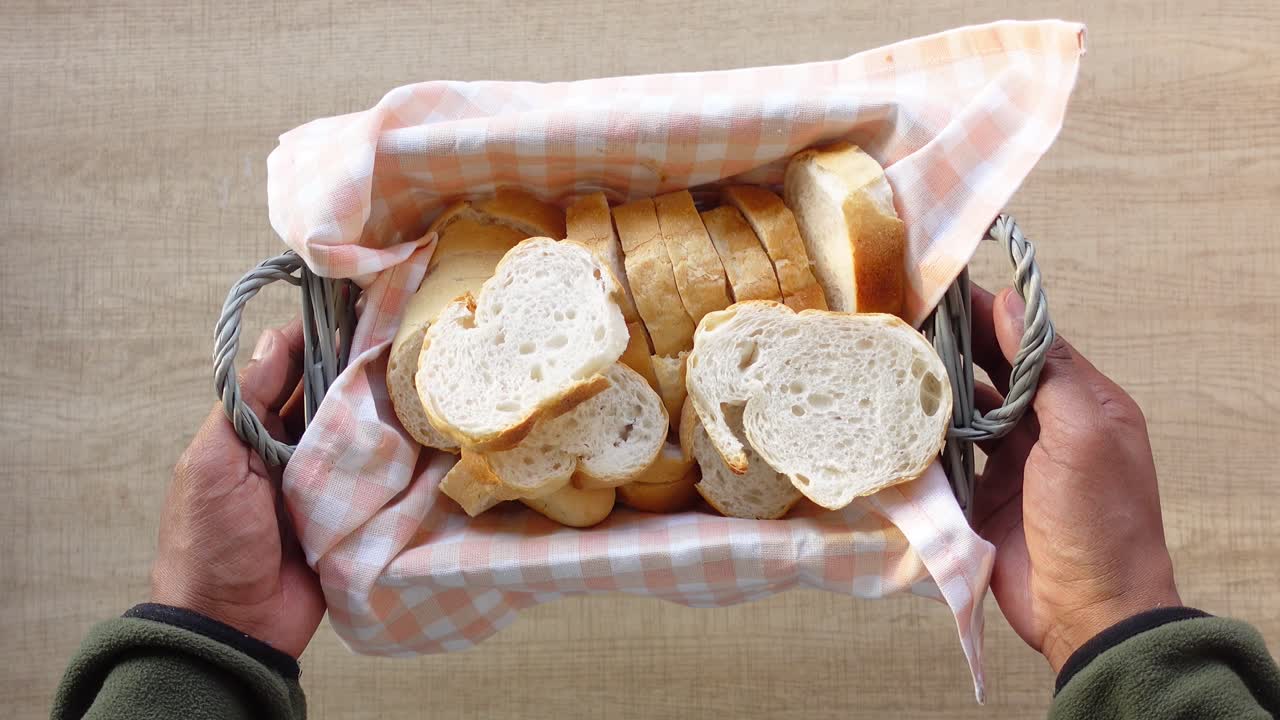 Hand holding a basket of sliced bread