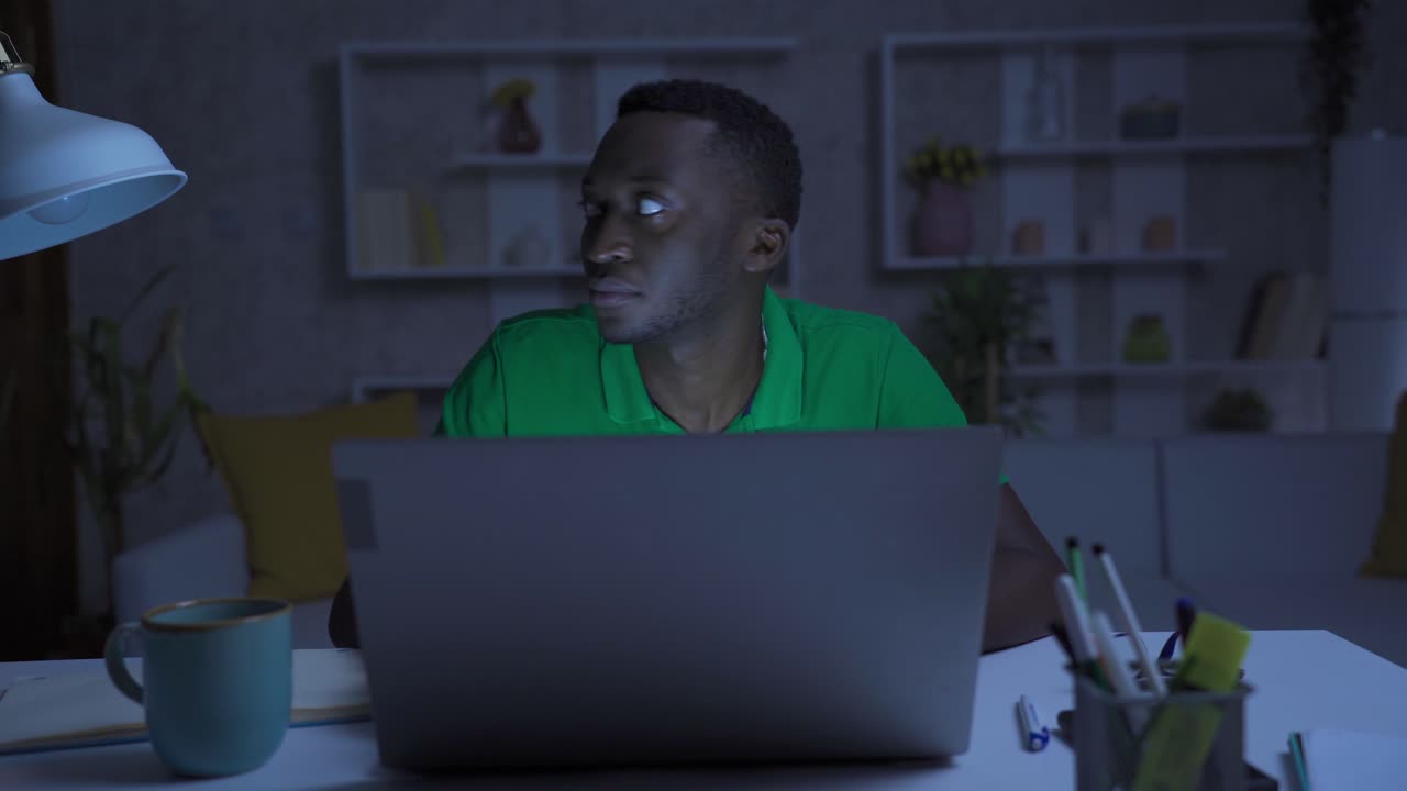 African black man working in home office experiencing power outage.