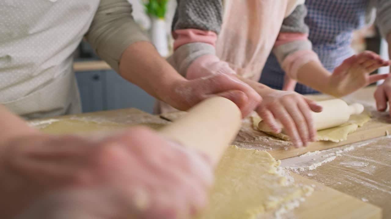 Close up video of three women rolling dough