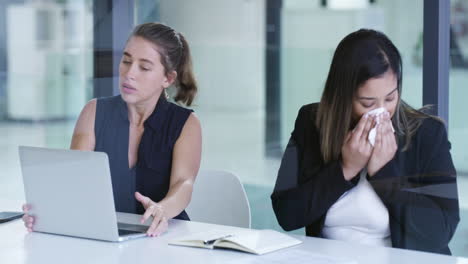 una joven mujer de negocios estornudando mientras está sentada
