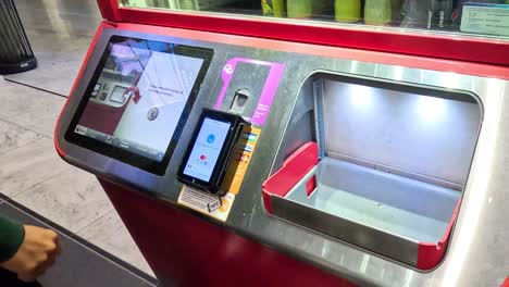 secuencia de un hombre usando un moderno dispensador de bebidas digital