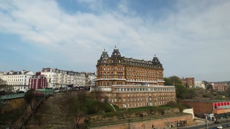 Video-Panorámico-Del-Gran-Hotel,-Un-Edificio-Catalogado-De-Grado-2,-Reflejado-En-La-Arena-Húmeda-De-La-Playa-De-Scarborough-En-Un-Hermoso-Día-De-Invierno