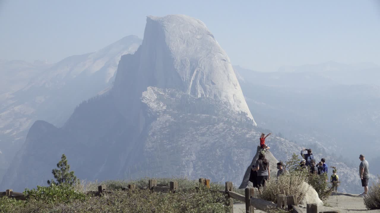 мальчик на скале у ледника в национальном парке йосемити полкупола и горы сьерра-невада вдали