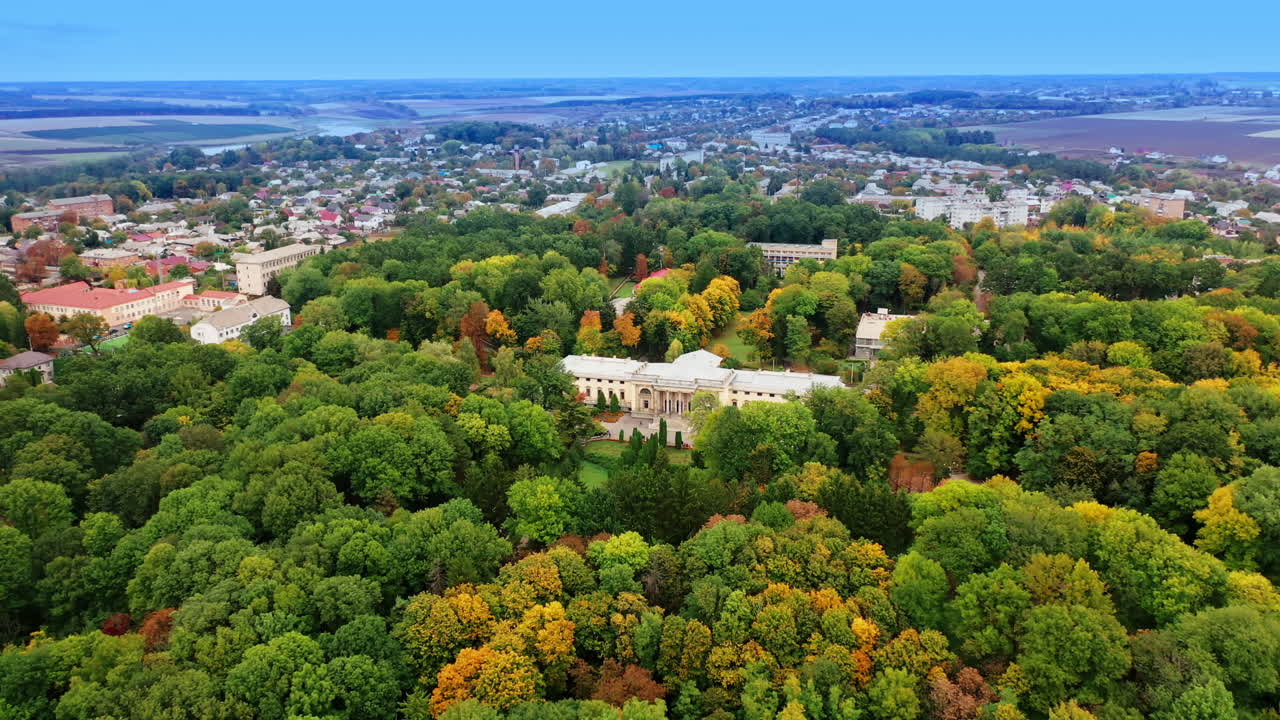 Splendid view of the green park growing around beautiful palace. Provincial cityscape at backdrop of hazy horizon.