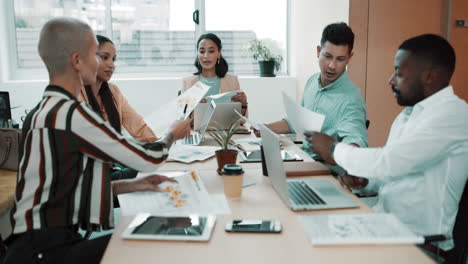 Diverse-group-of-businesspeople-passing-paperwork