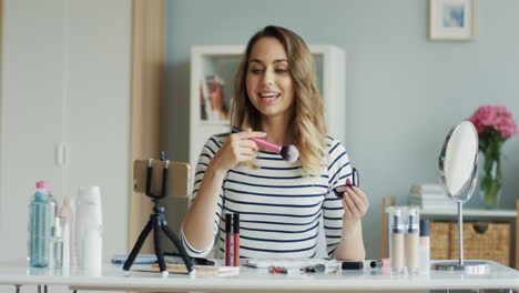 Hübsche-Beauty-Bloggerin,-Die-Ein-Make-up-Tutorial-Video-Mit-Dem-Smartphone-Aufnimmt-Und-Lehrt,-Wie-Man-Rouge-Auf-Die-Wangen-Aufträgt