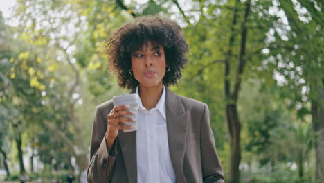 woman walking city park enjoying coffee takeaway closeup. business lady drinking
