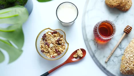 healthy breakfast with granola, milk, honey, and bread