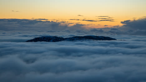 beautiful inversion clouds immersing and dancing around two mountains in bergen, norway