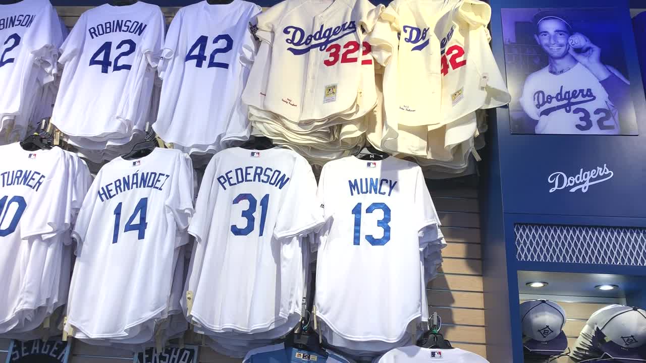 A wall display of baseball player jerseys and t-shirts of the Los Angeles Dodgers major league baseball team. One of the biggest fan stores for LA Dodgers fans.