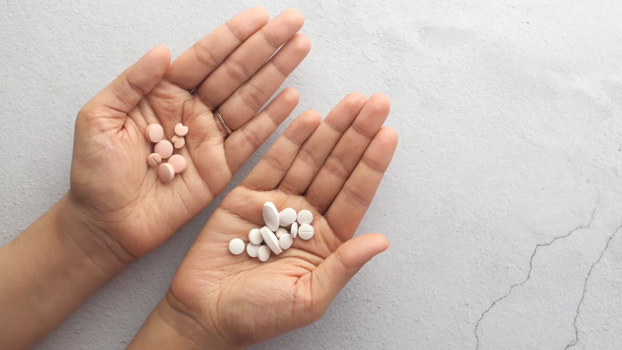 다른 색의 약을 들고 있는 손