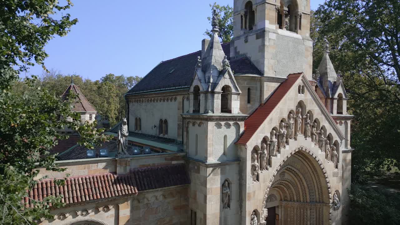 Side view of Ják Chapel highlighting its Romanesque towers and statues