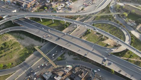 4k: avión no tripulado volando sobre un paso elevado de tráfico con tráfico urbano en curso en punjab, pakistán